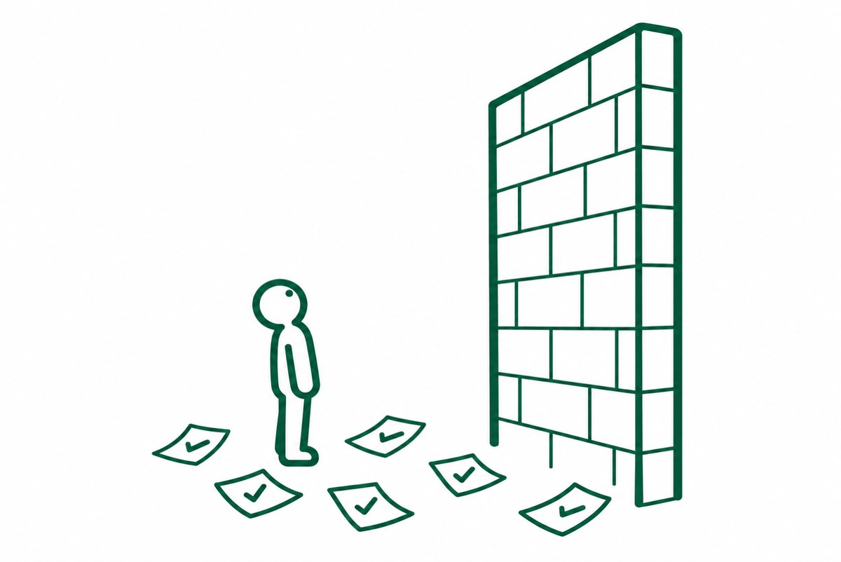 試し終えた紙の前で壁を見上げる人の図